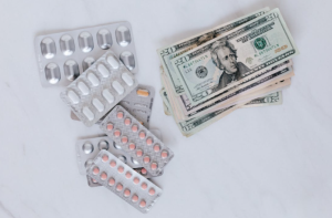 Pills and money symbolizing healthcare expenses